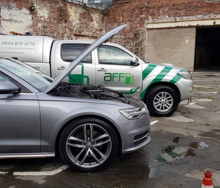 Recharge technician charging an electric vehicle at the roadside